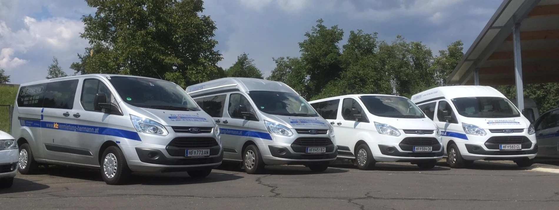 Vier 9-Sitzer Busse von Ford nebeneinander